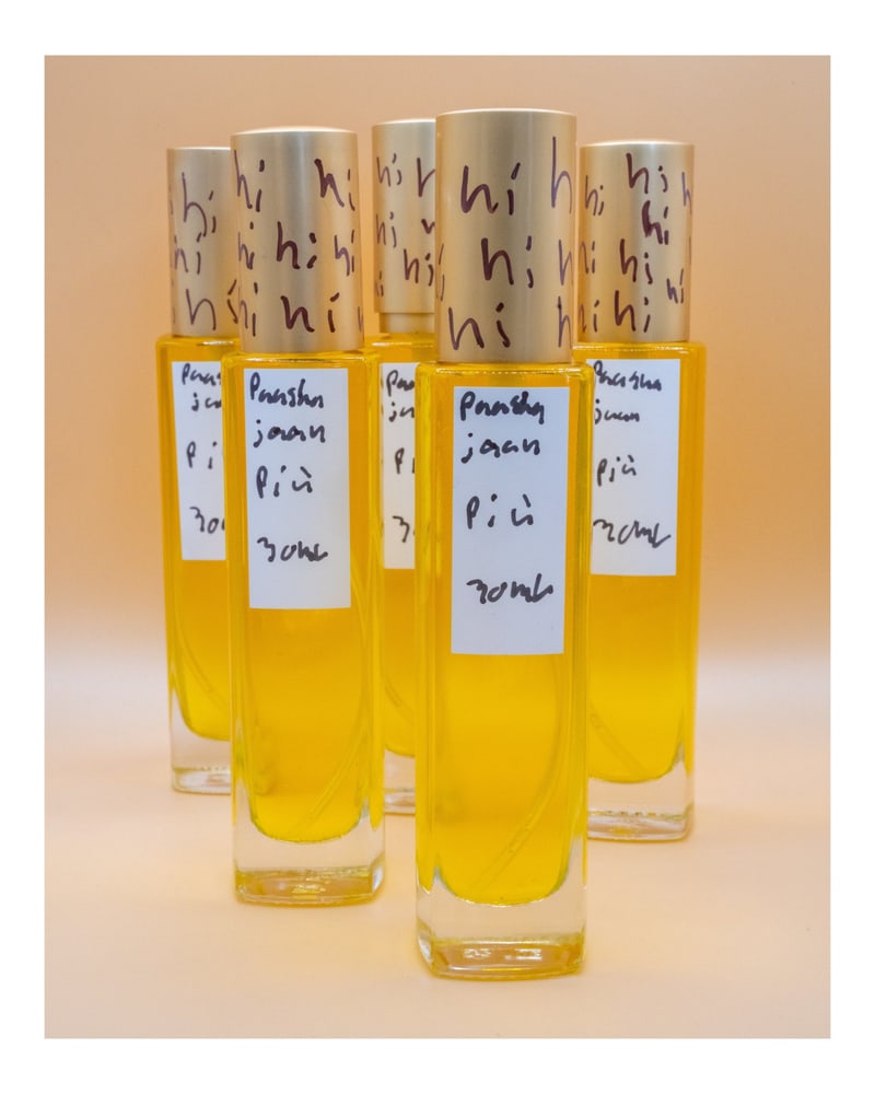 Five 30ml bottles of the artist's perfume, filled with a deep yellow oil, hand-labelled "paasha joon pici" with "hi" written over the caps